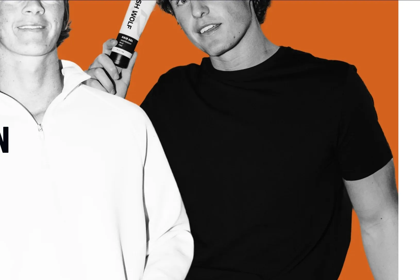 Two young men in black and white on an orange panel, one holding Fresh Wolf hair gel